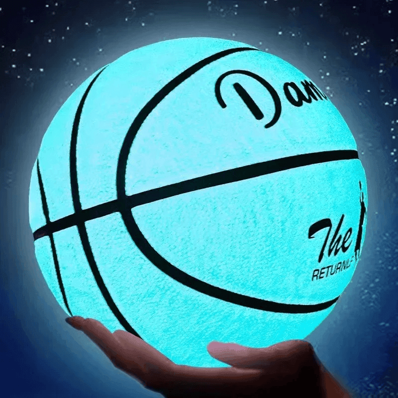 Glow in the dark basketball glowing bright blue at night, luminous basketball held in hand