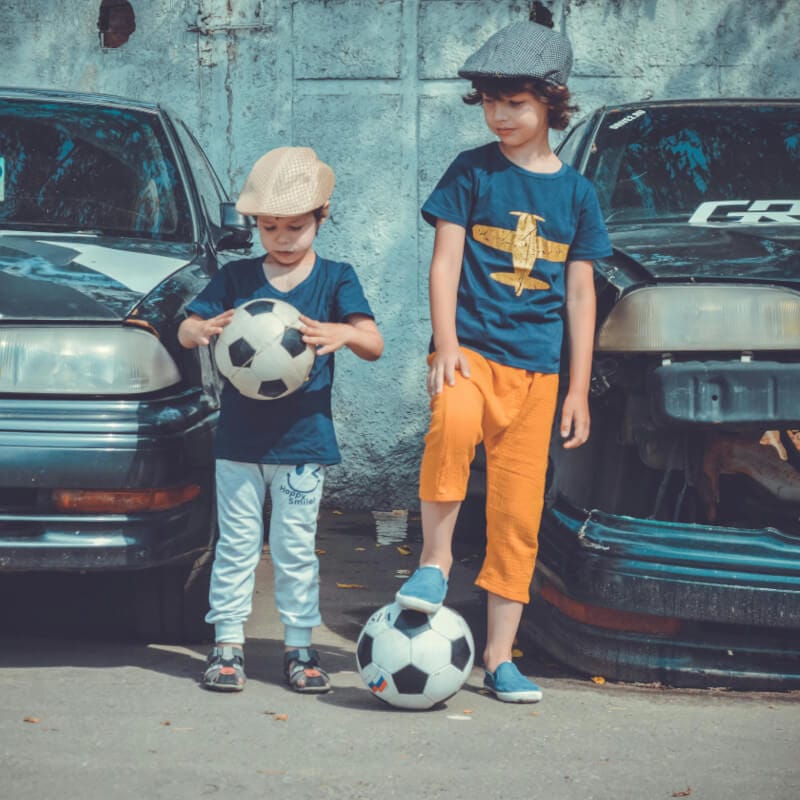 Two little boys playing with soccer football ball, kids football training scene, custom football ball manufacturer
